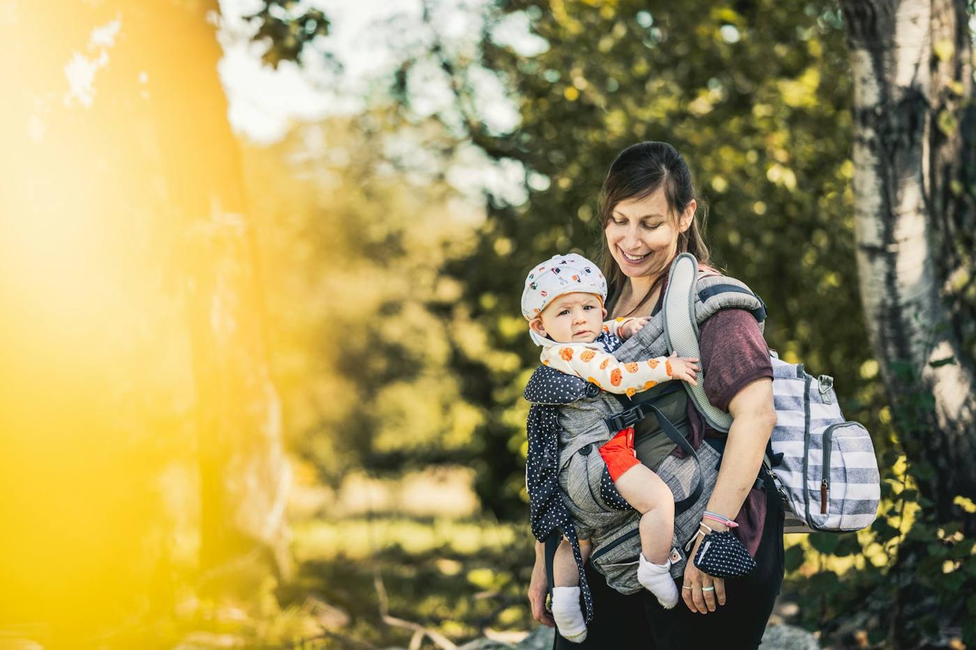 Mutter mit Baby in der Trage im Wald